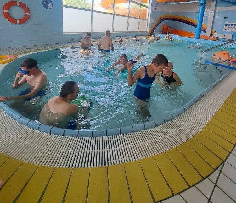 Grupa mieszkańców DPS bawi się w basenie