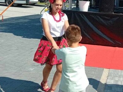 Chłopiec i dziewczynka trzymają się za ręce i tańczą. 
