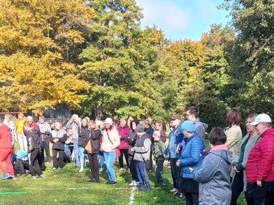 Grupa kibicujących uczestników wydarzenia podczas zawodów sportowych.