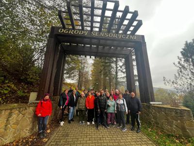 Zbiorowe zdjęcie uczestników wycieczki w bramie do ogrodów sensorycznych.