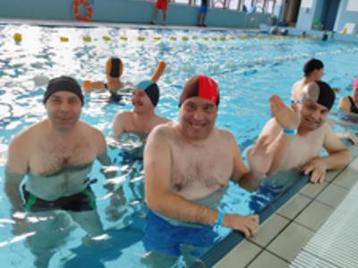Grupa uczestników wycieczki przygotowuje się w krytym basenie do aqua gimnastyki.