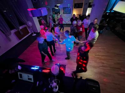 Grupa uczestników wycieczki tańczy podczas wieczornej potańcówki.