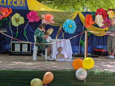 Młoda kobieta przebrana siedzi za stołem na scenie.