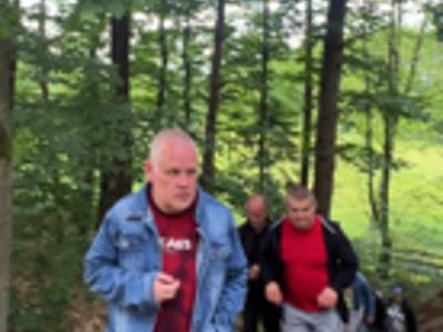 Grupa uczestników wycieczki wchodzi pod górę w Parku Krajobrazowym.