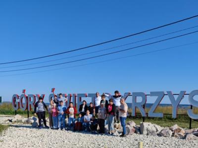 Zdjęcie grupowe uczestników wycieczki na tle napisu Góry Świętokrzyskie