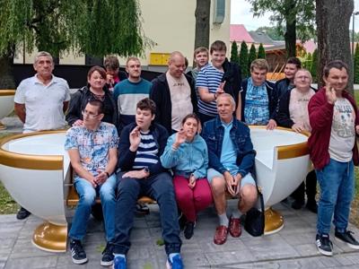 Zdjęcie grupowe uczestników wycieczki na tle filiżanki ławki w Ćmielowie