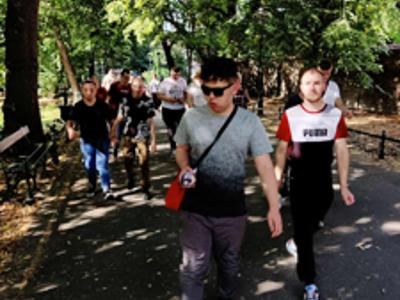 Grupa uczestników wycieczki idzie alejkami na Plantach.
