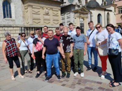 Grupa uczestników wycieczki pozuje do zdjęcia na tle Kaplicy Zygmuntowskiej na Wawelu
