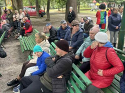 Uczestnicy wydarzenia siedzący na ławkach