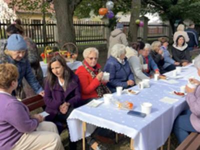 Uczestnicy wydarzenia siedzący przy stołach biesiadnych 