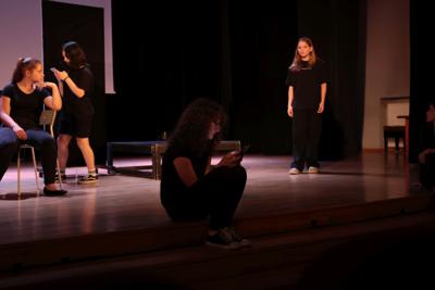 Fragment występu teatralnego w ramach LKA Finał Wojewódzki TEATR 2024 - na scenie 4 aktorki, zamyślone, zapatrzone w telefony komórkowe.