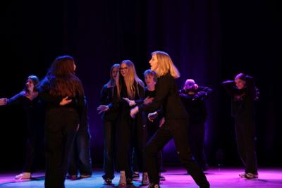 Fragment występu teatralnego w ramach LKA Finał Wojewódzki TEATR 2024 - scena przepychanki w grupie postaci.