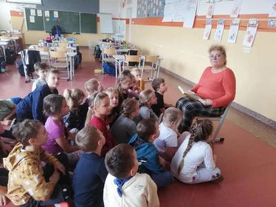 Babcia ucznia czyta dzieciom