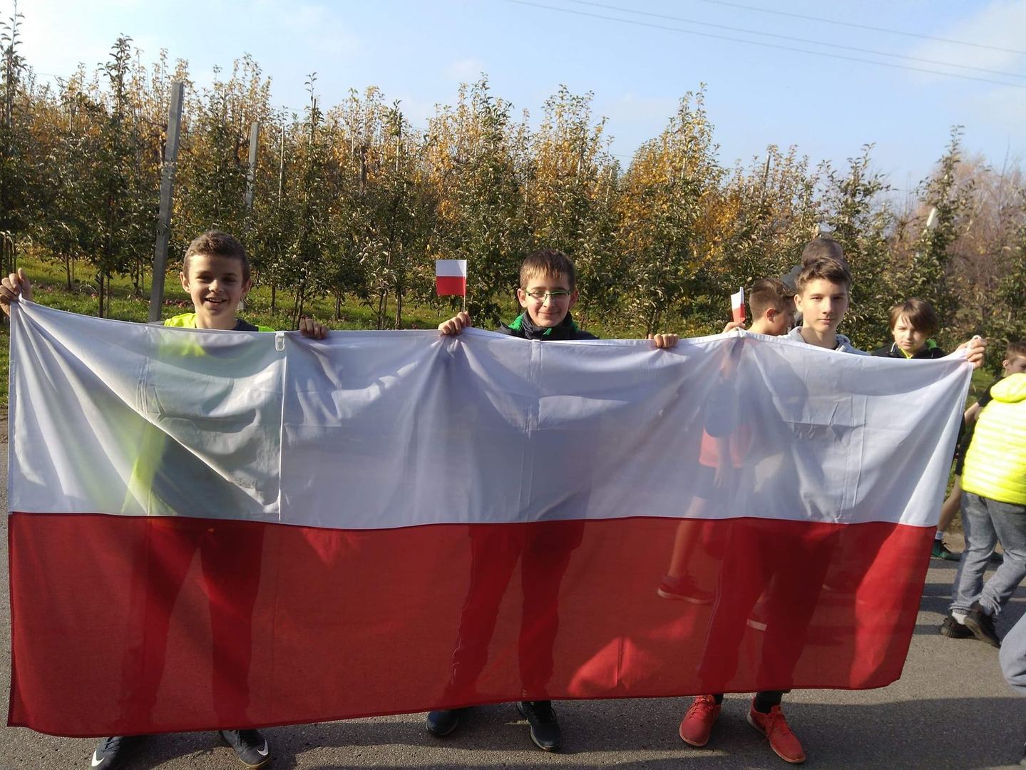 Trzymanie flagi przez 3  chłopców
