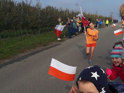 Dziecko biegnące z dużą flagą