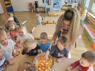 Dzieci pomagające przygotować sok owocowo-warzywny.