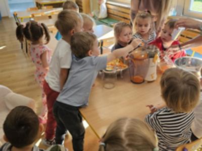 Dzieci pomagające przygotować sok owocowo-warzywny.