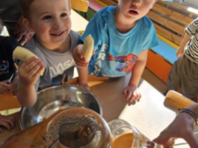 Dzieci pomagające przygotować sok owocowo-warzywny.