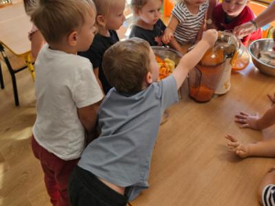 Dzieci pomagające przygotować sok owocowo-warzywny.