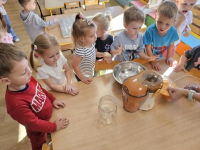 Dzieci pomagające przygotować sok owocowo-warzywny.