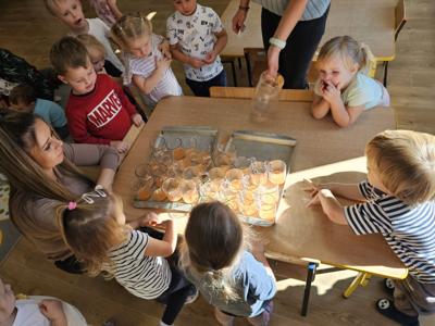 Dzieci pomagające przygotować sok owocowo-warzywny.