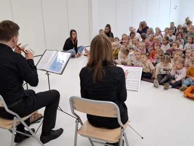 Muzycy i dzieci podczas koncertu filharmonii.