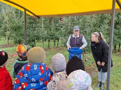 Dzieci słuchające lekcji na temat zawodu sadownika.