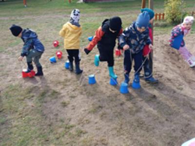 Dzieci podczas próby chodzenia na szczudłach.