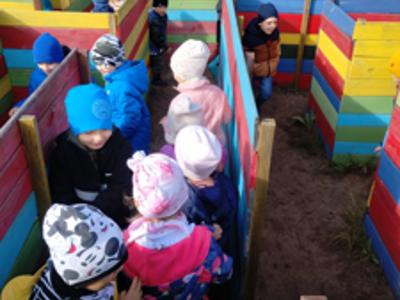 Grupa przedszkolaków podczas szukania jajek w labiryncie.