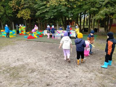 Dzieci podczas zabaw dużymi klockami oraz puszczania baniek na świeżym powietrzu.
