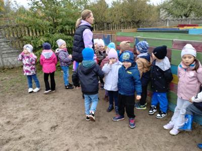 Grupa przedszkolaków na tle kolorowego labiryntu.