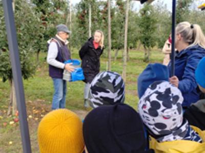 Dzieci słuchające lekcji na temat zawodu sadownika.