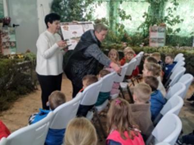 Dzieci słuchające wykładu na temat grzybów i oglądające eksponaty.