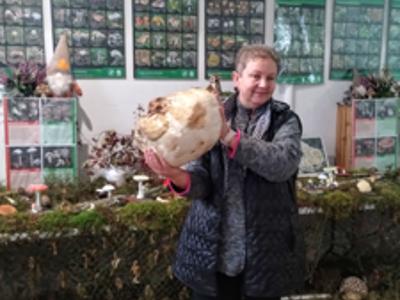 Prowadząca pokazująca największy grzyb na wystawie.