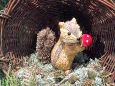 Model wiewiórki trzymającej muchomora.