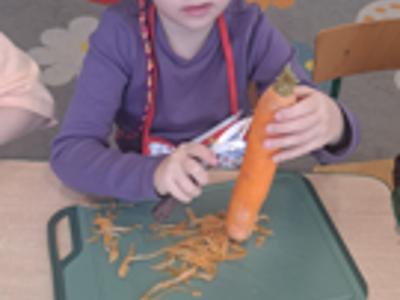 Przedszkolaki podczas obierania warzyw.