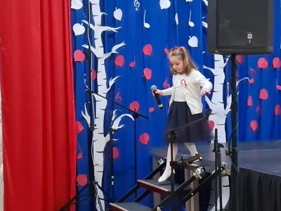 Dziewczynka śpiewa na scenie podczas konkursu piosenki.
