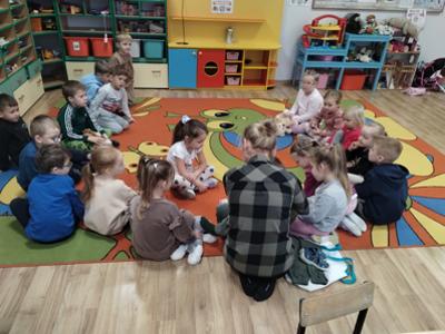 Przedszkolaki podczas czytania bajki przez rodzica.