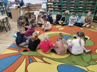 Przedszkolaki podczas czytania bajki przez rodzica.