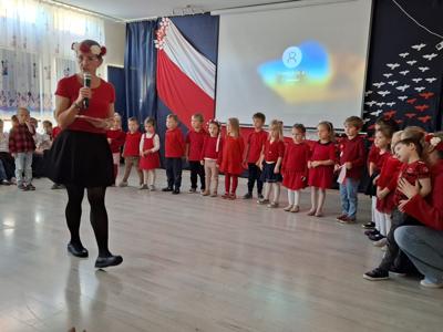 Grupa przedszkolaków podczas recytowania wiersza patriotycznego.