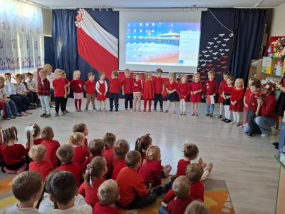 Grupa przedszkolaków podczas recytowania wiersza patriotycznego.