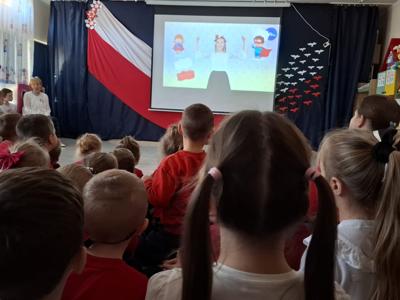 Grupa przedszkolaków podczas oglądania filmu edukacyjnego o polskich symbolach narodowych.