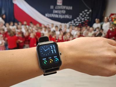 Zegarek z godziną jedenastą jedenaście na tle grupy przedszkolaków.