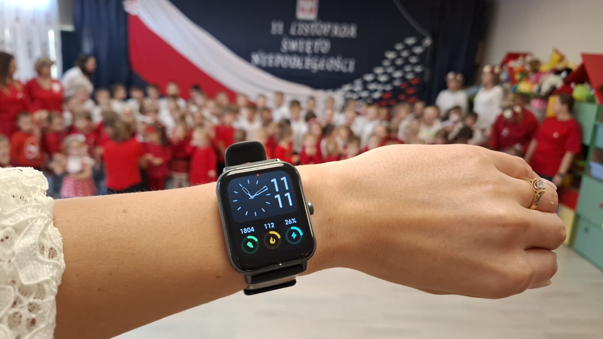 Zegarek z godziną jedenastą jedenaście na tle grupy przedszkolaków.