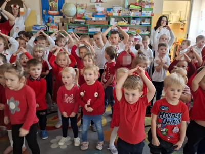 Grupa przedszkolaków podczas śpiewania piosenki patriotycznej.