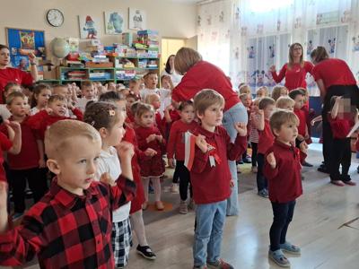 Grupa przedszkolaków podczas śpiewania piosenki patriotycznej.