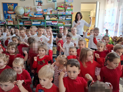 Grupa przedszkolaków podczas śpiewania piosenki patriotycznej.