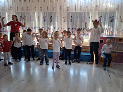 Grupa przedszkolaków podczas śpiewania piosenki patriotycznej.