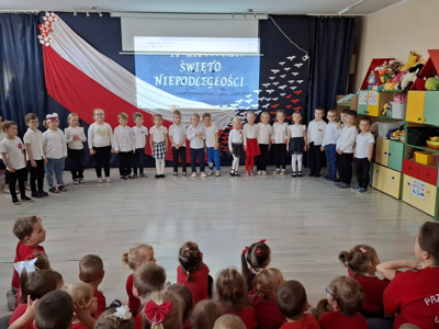 Grupa przedszkolaków podczas recytowania wiersza patriotycznego.