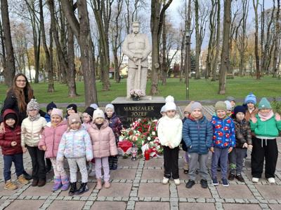 Grupa przedszkolna na tle pomnika Józefa Piłsudzkiego.